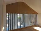 Boiserie in legno che chiude un soppalco all'interno di un ingresso di un'abitazione moderna_1