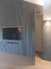 Boiserie in legno grigio chiaro con televisore a schermo piatto al suo interno, e, porta laterale aperta_1