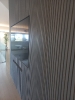 Boiserie in legno grigio con televisore a schermo piatto inserito al suo interno_1