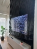 Vista laterale parete boiserie di colore nero all'interno di un soggiorno di un mansardato con incastonato un televisore a schermo piatto acceso_1