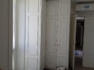 Camera da letto dettagli armadio ad angolo in legno di colore bianco con manopole di colore oro_1