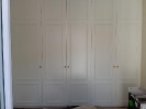 Camera da letto vista frontale armadio di colore bianco con manopole di colore oro_1